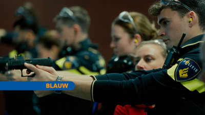 Student Jip en docent Carmen tijdens zijn eerste keer schieten. Tekst: Blauw.