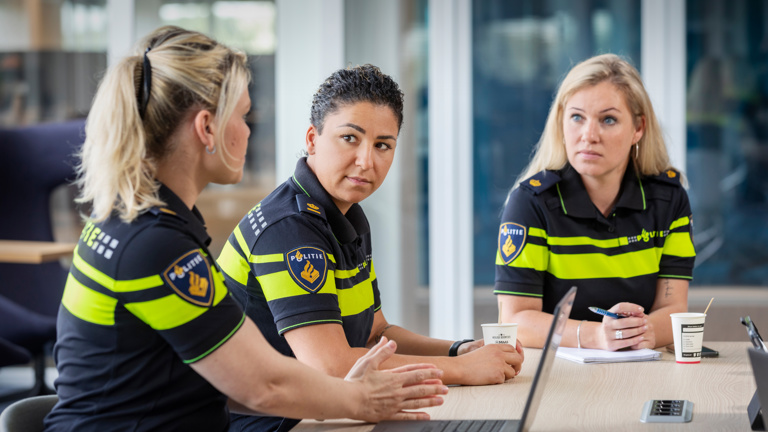 Politieacademie studierichting Tactisch/strategisch leiderschap - Drie vrouwelijke studenten in uniform zitten aan tafel 