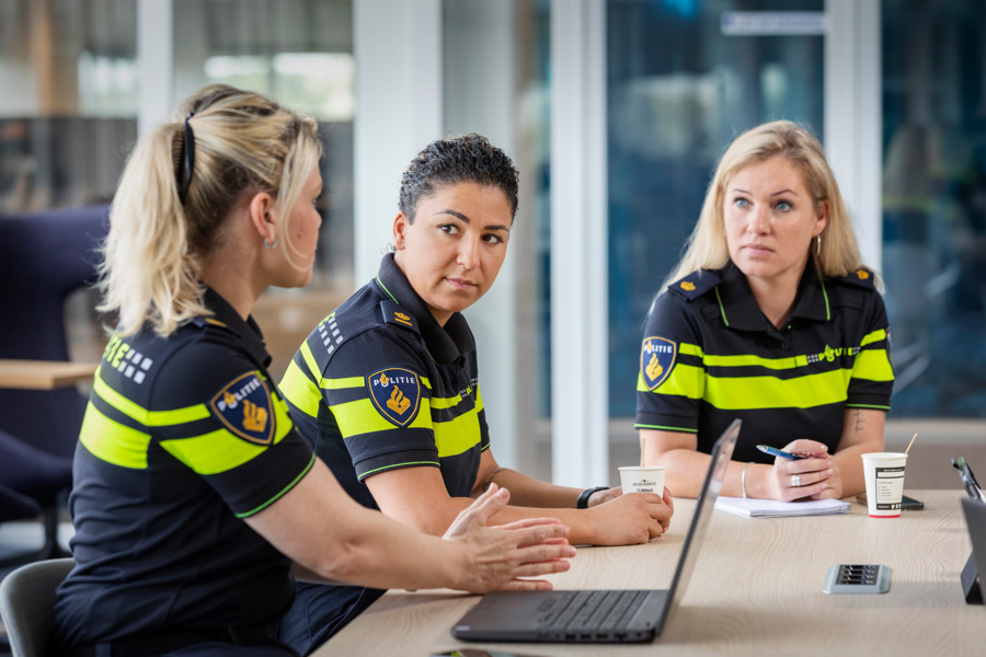 Politieacademie studierichting Tactisch/strategisch leiderschap -Drie vrouwelijke studenten in uniform zitten aan tafel 