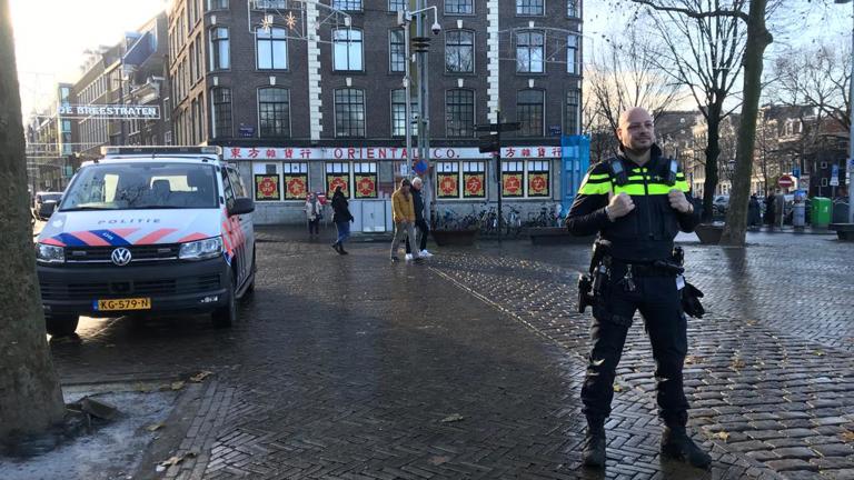 Jovanny op de Nieuwmarkt in Amsterdam met een politieauto