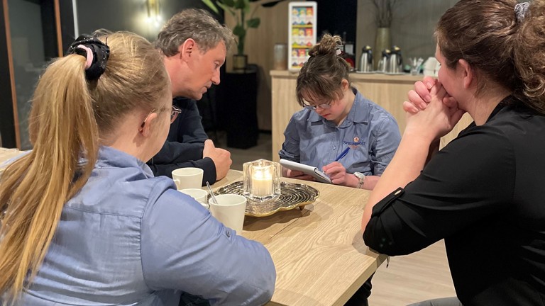 Twee verhoorstudenten en twee studenten van Parc Spelderholt in gesprek aan een hoge tafel.