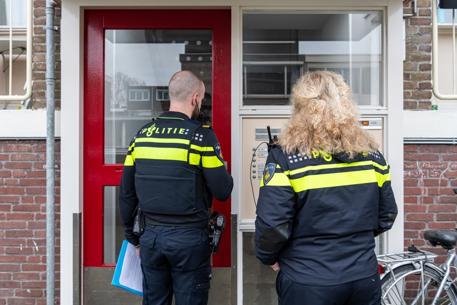 Politieacademie studierichting Wijkagent - Twee agenten staan voor portaal flat