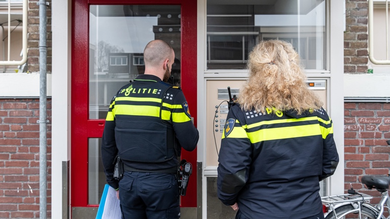 Politieacademie studierichting Wijkagent - Twee agenten staan voor portaal flatgebouw