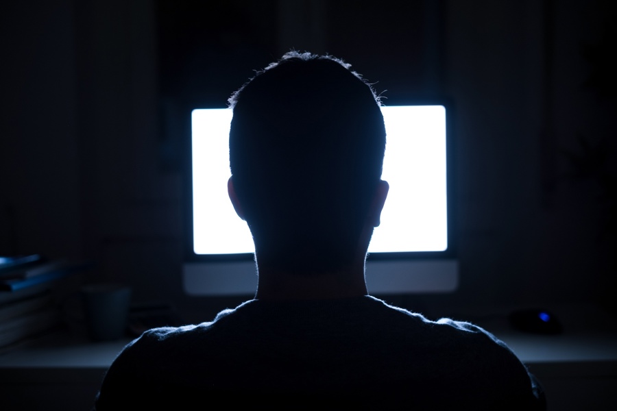 Politieacademie studierichting Informatie inwinnen - silhouet van man die naar verlicht beeldscherm kijkt