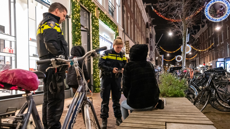 Politieagenten in gesprek met iemand op een bankje