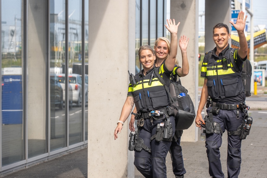 Studeren bij de Politieacademie - Drie studenten in uniform zwaaien richting camera