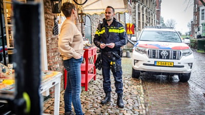 Een agent in gesprek met een winkelier op straat