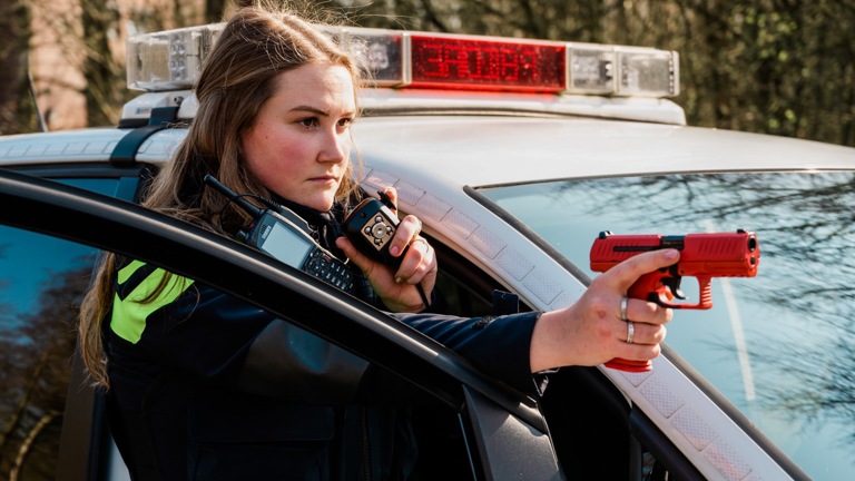 Student Linda met oefenwapen bij politieauto