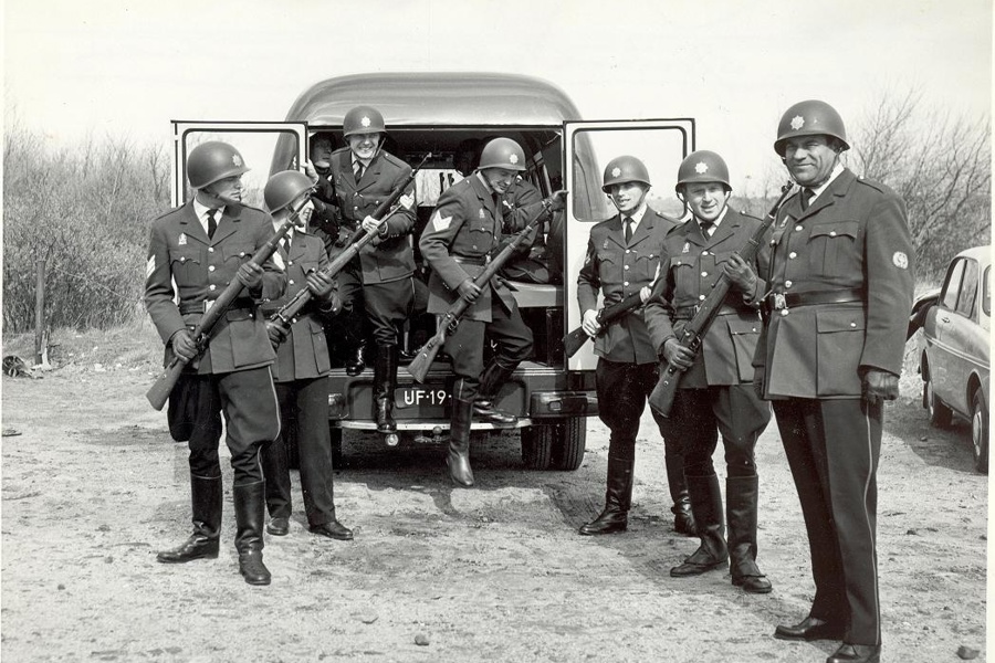 Zwartwit afbeelding uit de vorige eeuw van groepje gehelmde politieagenten in uniform
