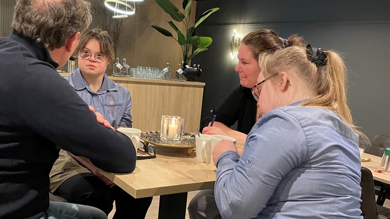 Twee verhoorstudenten en twee studenten van Parc Spelderholt in gesprek aan een hoge tafel.