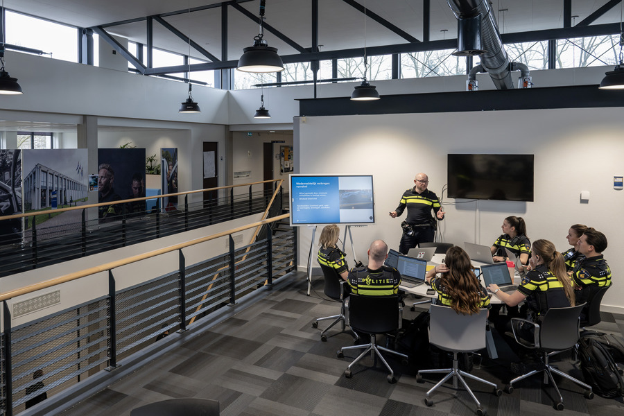 Docent met groepje studenten aan een ronde tafel