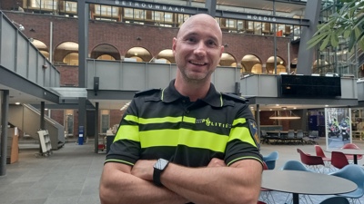 Docent Daniël staat in het atrium van de Politieacademie in Apeldoorn