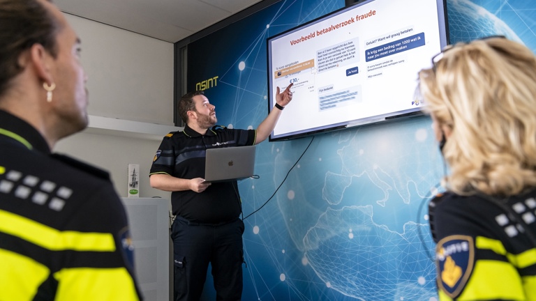 Politieacademie studierichting Cybercrime en digitale opsporing - twee studenten kijken naar beeldscherm waar docent uitleg geeft