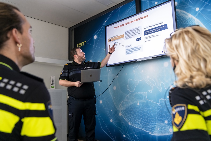 Politieacademie studierichting Cybercrime en digitale opsporing - Twee studenten kijken naar scherm waar docent uitleg geeft