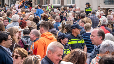 Two police officers in the middle of a big crowd on the street