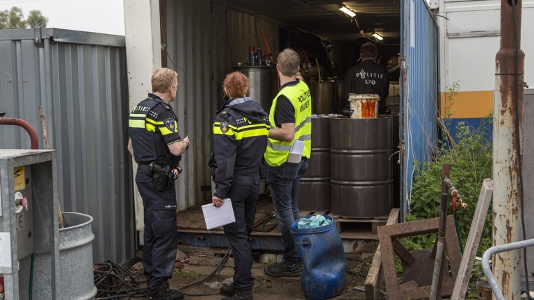 Politieacademie studierichting Milieucriminaliteit - drie agenten kijken naar inhoud openstaande zeecontainer