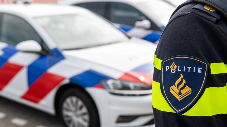 Politieauto en schouder politieagent met embleem politie