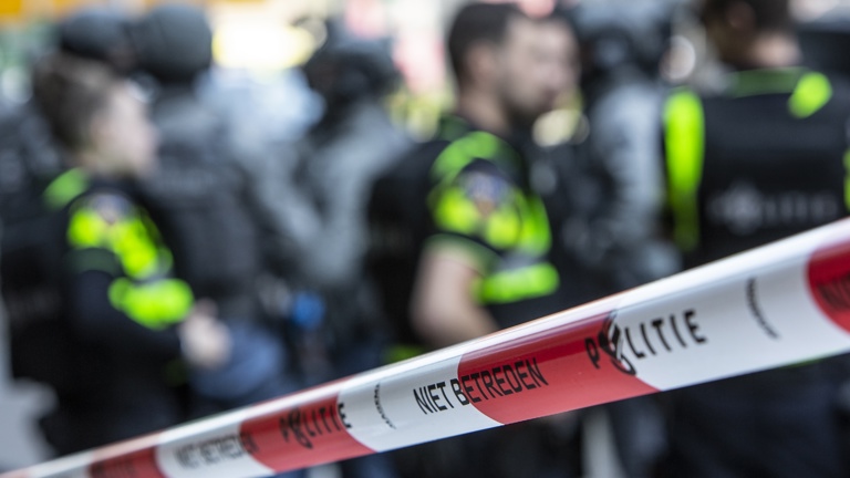 Politieacademie studierichting Grootschalig optreden - afzetlint en politieagenten vervaagd op achtergrond