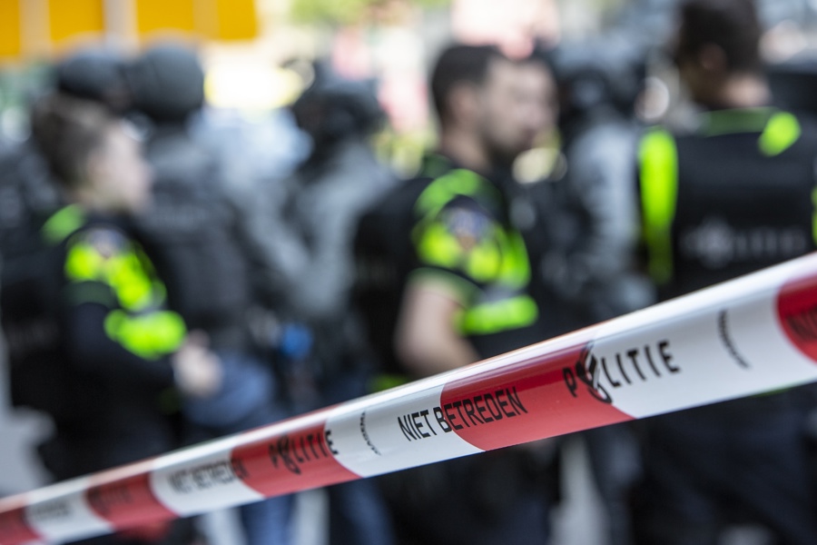 Politieacademie studierichting Grootschalig optreden - afzetlint en vervaagd op achtergrond politieagenten