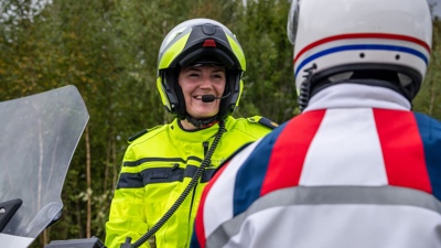 Docent Estée in motoruniform in gesprek met burger