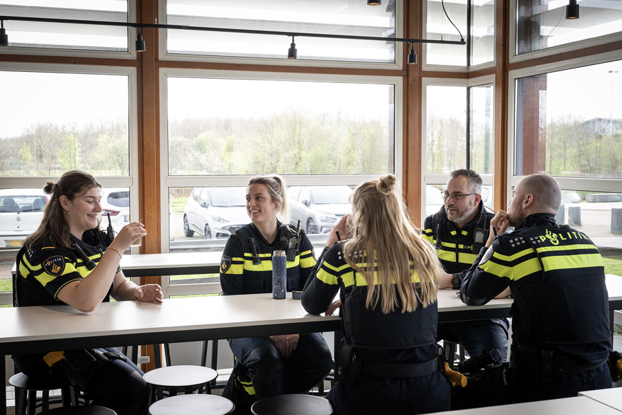 Praktische informatie Politieacademie - groep studenten in uniform zit aan lange tafel